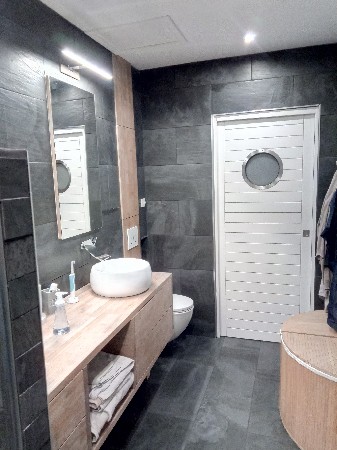 rénovation salle de bain avec suppression pièce wc, pose d'une porte a galandage, création du meuble massif épicea, et carrelage ardoise.