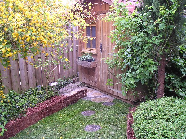 petit jardin avec pose de gazon pré cultivé en rouleaux. Habillage avec pas japonais et pierre naturelle en Opus.