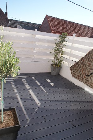 Réalisation d'une terrasse en composite sur un "balcon terrasse", plantation d'un olivier sur tige et d'un trachelospermum